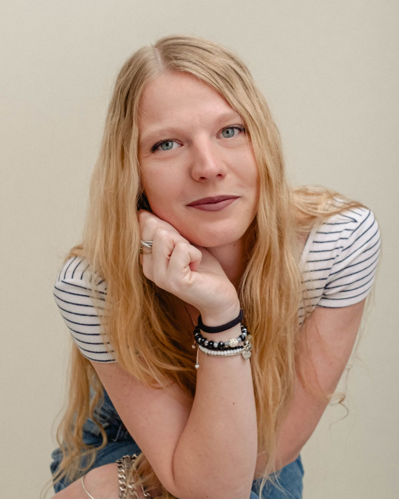 Kassandra resting her chin on her hand in a striped top